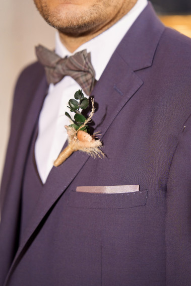 Costume SUAT violet. Plan sur le nœuds papillon à motif et un pins bouquet de fleur.