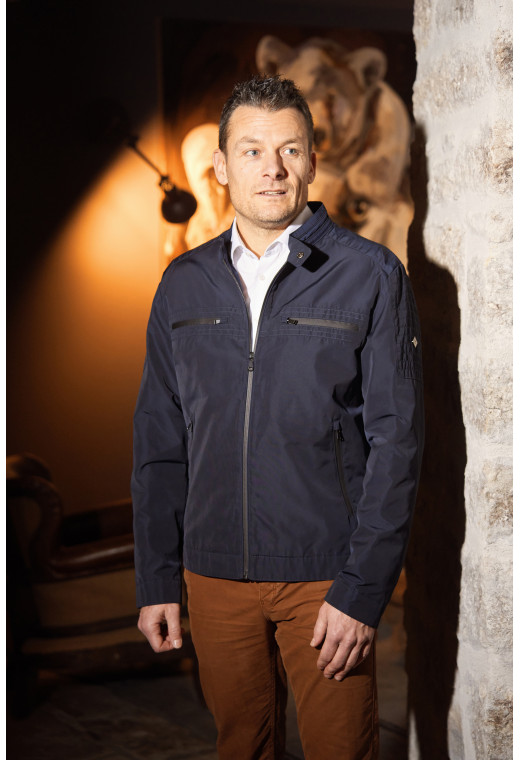 Homme portant le blouson ARTHUS bleu. Il comporte 2 poches poitrine et 2 poches repose mains.