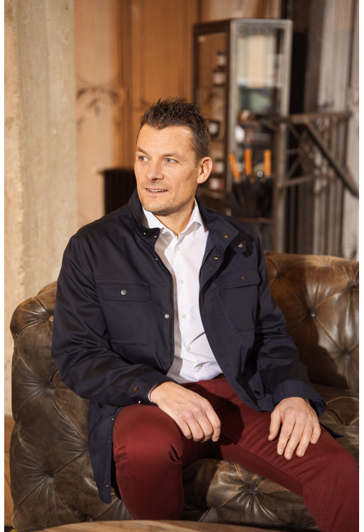 Homme portant la surveste AUBURNE marine. Elle comporte 2 poches poitrine, 2 poches plaquées avec rabat.