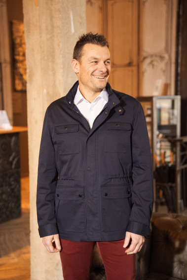 Homme portant la surveste AUBURNE marine. Elle comporte 2 poches poitrine, 2 poches plaquées avec rabat.