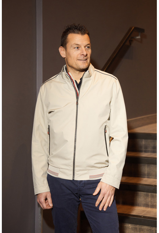 Homme portant le blouson FLAG beige. Il comporte 2 poches repose mains.