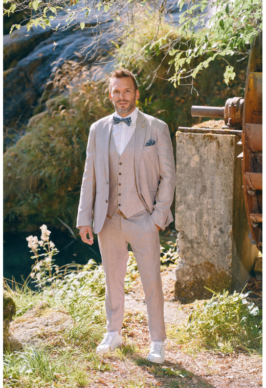Homme de profil portant la veste TROPICAL rose poudré. Elle comporte une poche poitrine et 2 poches plaquées.