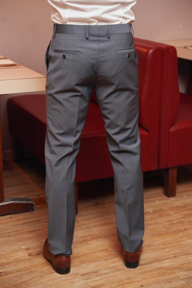 Homme de dos portant le pantalon TECHP gris. Il comporte 2 poches avant et 2 poches arrière.