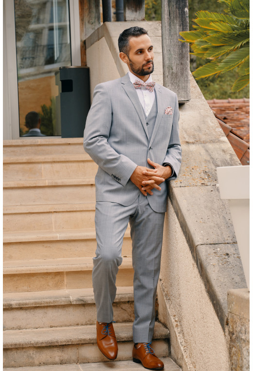 Homme portant la veste TECHV gris clair. Elle comporte une poche poitrine et 2 poches à rabat.