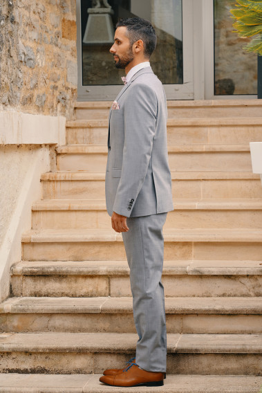 Homme de profil portant la veste TECHV gris clair.