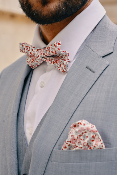 Zoom sur la veste TECHV gris clair. L'homme porte une nœuds papillon et un mouchoir de poche.