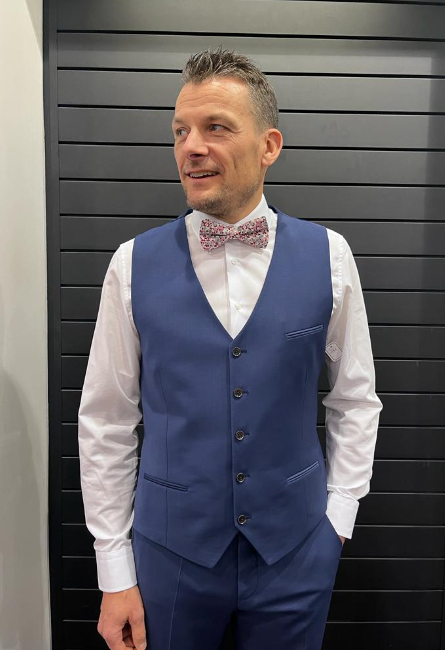 Homme portant le gilet CHRIS bleu accompagné d'un nœuds papillon.