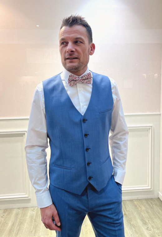 Homme portant le gilet CHRIS bleu accompagné d'un nœuds papillon.