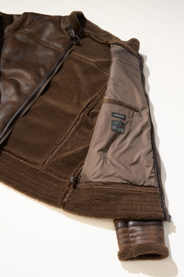 Zoom sur l'intérieur du blouson CARACAS marron. Il comporte 3 poches intérieures et il est en fausse fourrure.