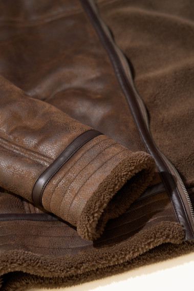 Zoom sur la manche du blouson CARACAS marron. Le bas de la manche comporte de la fausse fourrure.