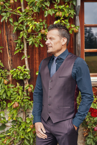 Homme en position trois-quarts portant le gilet CHRIS bordeaux. Il comporte 5 boutons.