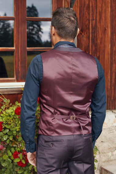 Homme de dos portant le gilet CHRIS bordeaux. Il comporte une patte de serrage dans le dos.