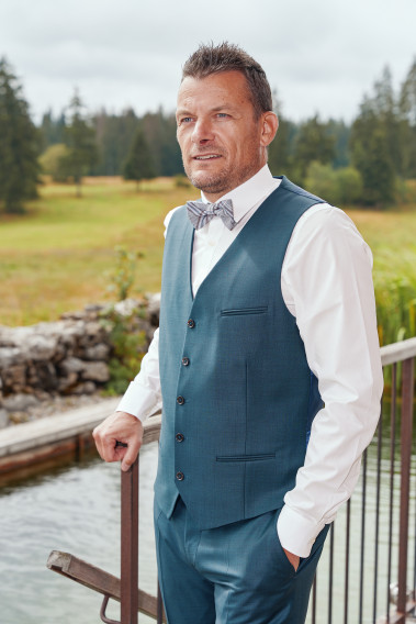 Homme portant le gilet CHRIS bleu vert. Il comporte 5 boutons.