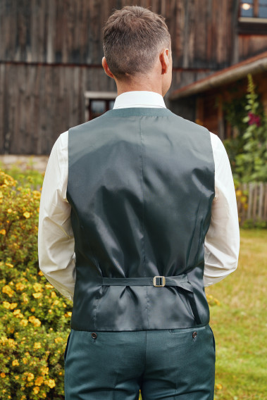 Homme de dos portant le gilet CHRIS vert. Elle comporte une patte de serrage dans le dos.