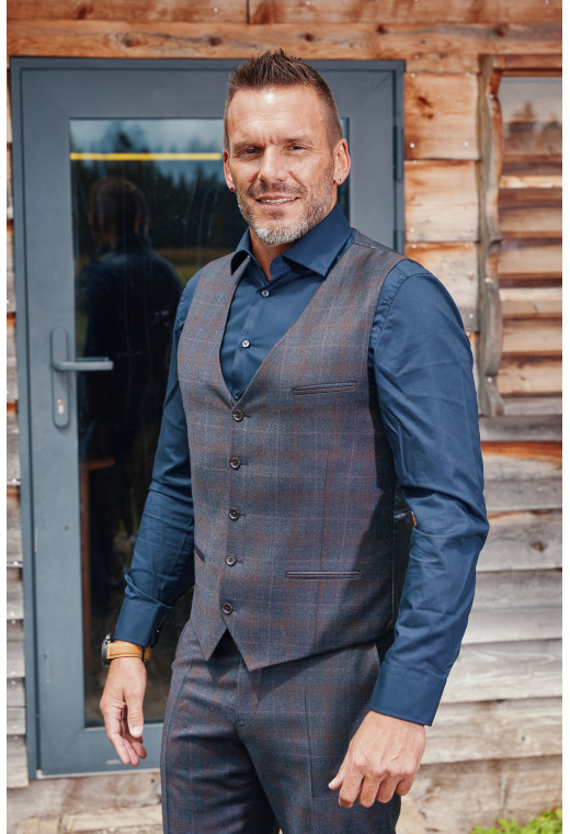 Homme de face portant le gilet CHRIS carreaux bordeaux. Elle comporte 5 boutons.