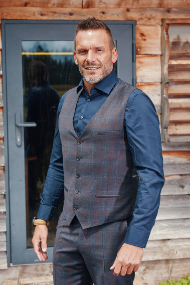 Homme de face portant le gilet CHRIS carreaux bordeaux. Elle comporte 5 boutons.