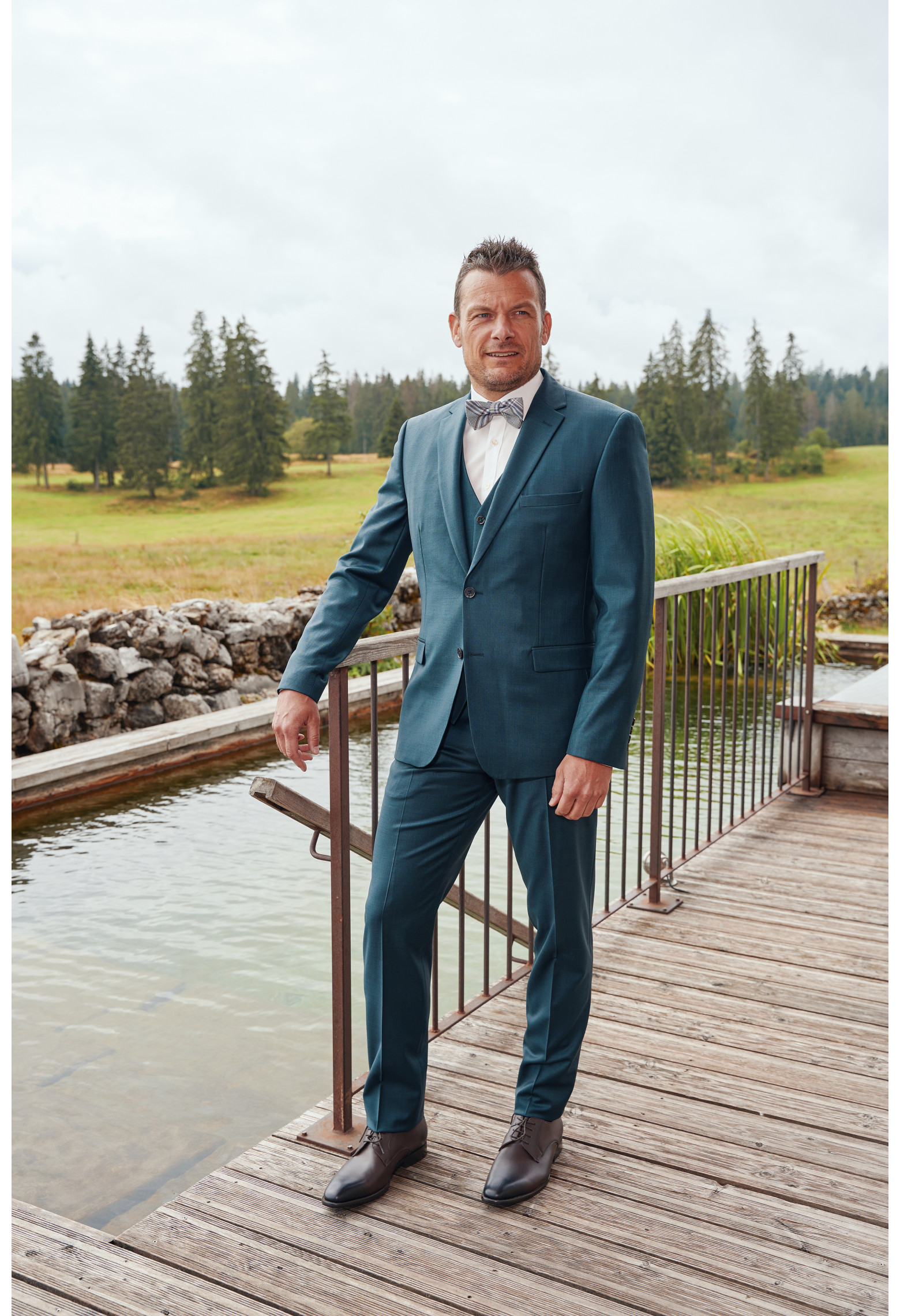 Homme de face en costume CITIZEN bleu vert 2 pièces.