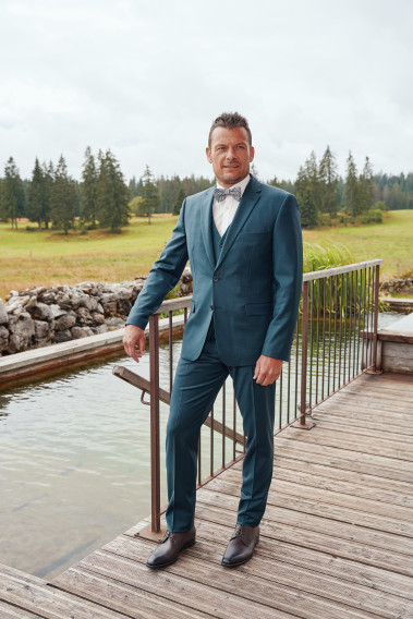 Homme de face en costume CITIZEN bleu vert 2 pièces.