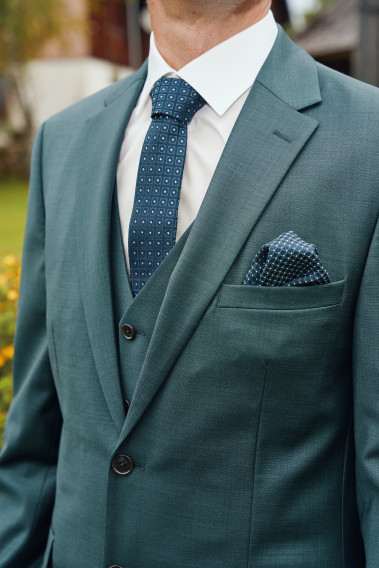 Costume CITIZEN vert. Plan sur la cravate verte et le mouchoir de poche assorti.