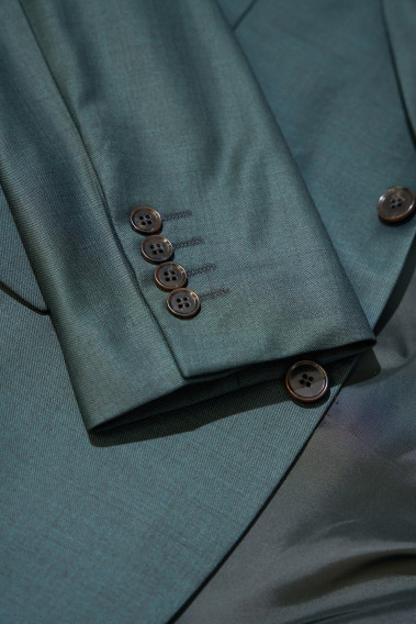 Zoom sur la manche du costume CITIZEN vert. Elle comporte 4 boutons.