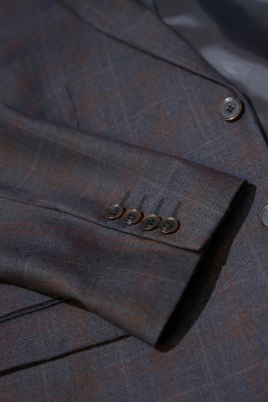 Zoom sur la manche du costume CITIZEN carreaux bordeaux. Elle comporte 4 boutons.