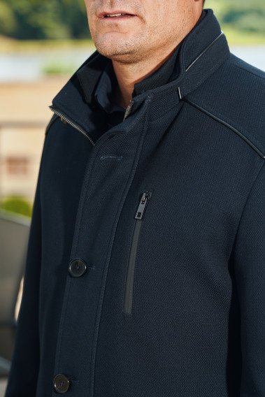 Zoom sur le col montant du manteau DIVALI marine.