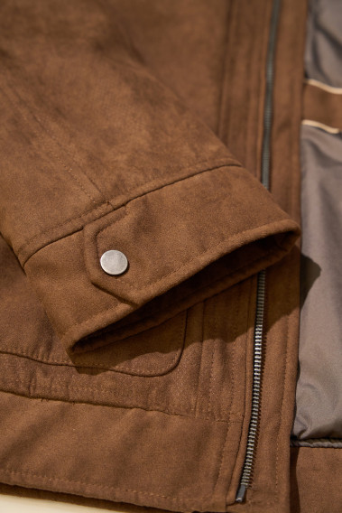 Zoom sur la manche qui comporte un bouton du blouson GIBSTON camel.