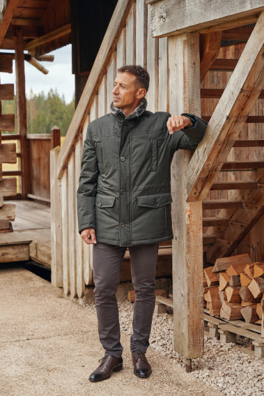 Homme portant la parka IVAR kaki. Elle comporte 4 poches.