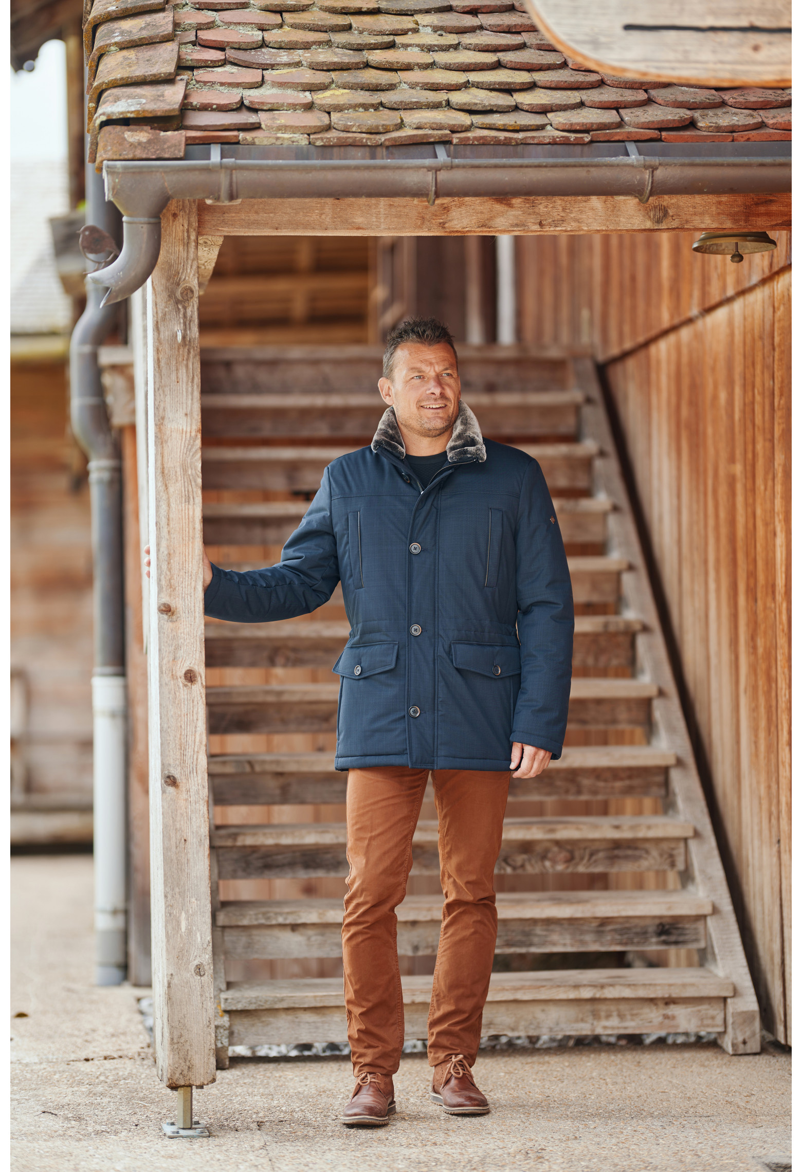 Homme portant la parka IVAR bleu. Elle comporte 4 poches.