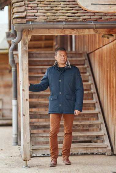 Homme portant la parka IVAR bleu. Elle comporte 4 poches.