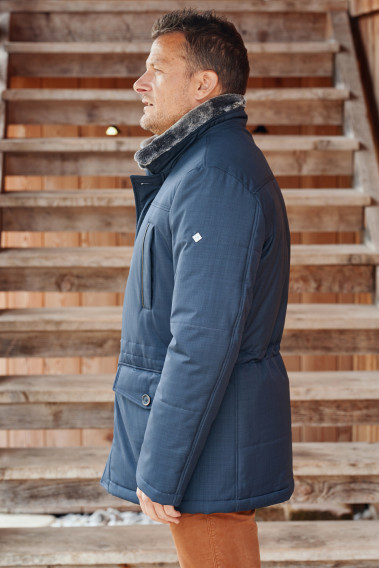 Homme de profil portant la parka IVAR bleu.