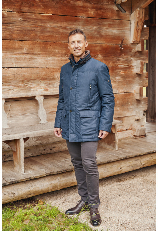 Homme portant la parka KAZAK bleu. Elle comporte 4 poches.