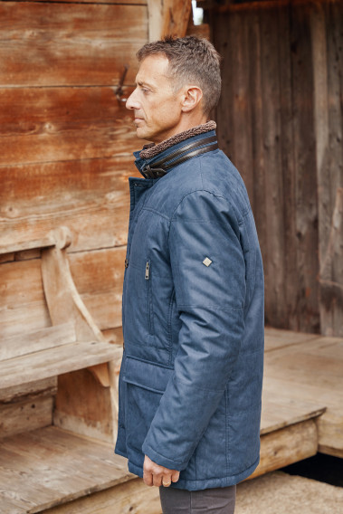 Homme de profil portant la parka KAZAK bleu.