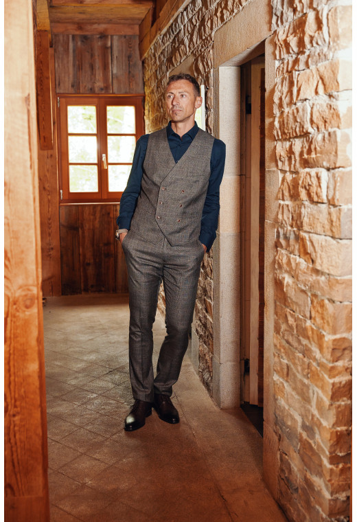 Homme portant le pantalon LINCOLN carreaux marron. Il comporte 3 poches avant et 2 poches arrière.