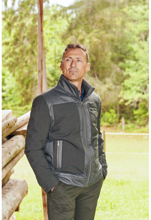 Homme portant la doudoune LOUKA kaki. Elle comporte une poche poitrine et 2 poches verticales.