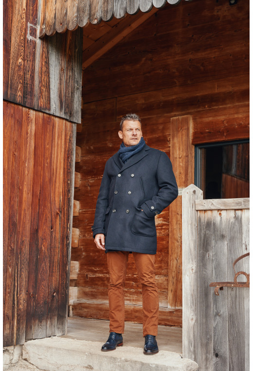 Homme portant le manteau caban LUCERNE marine. Il est long et comporte 2 poches poitrines et 2 poches plaquées.