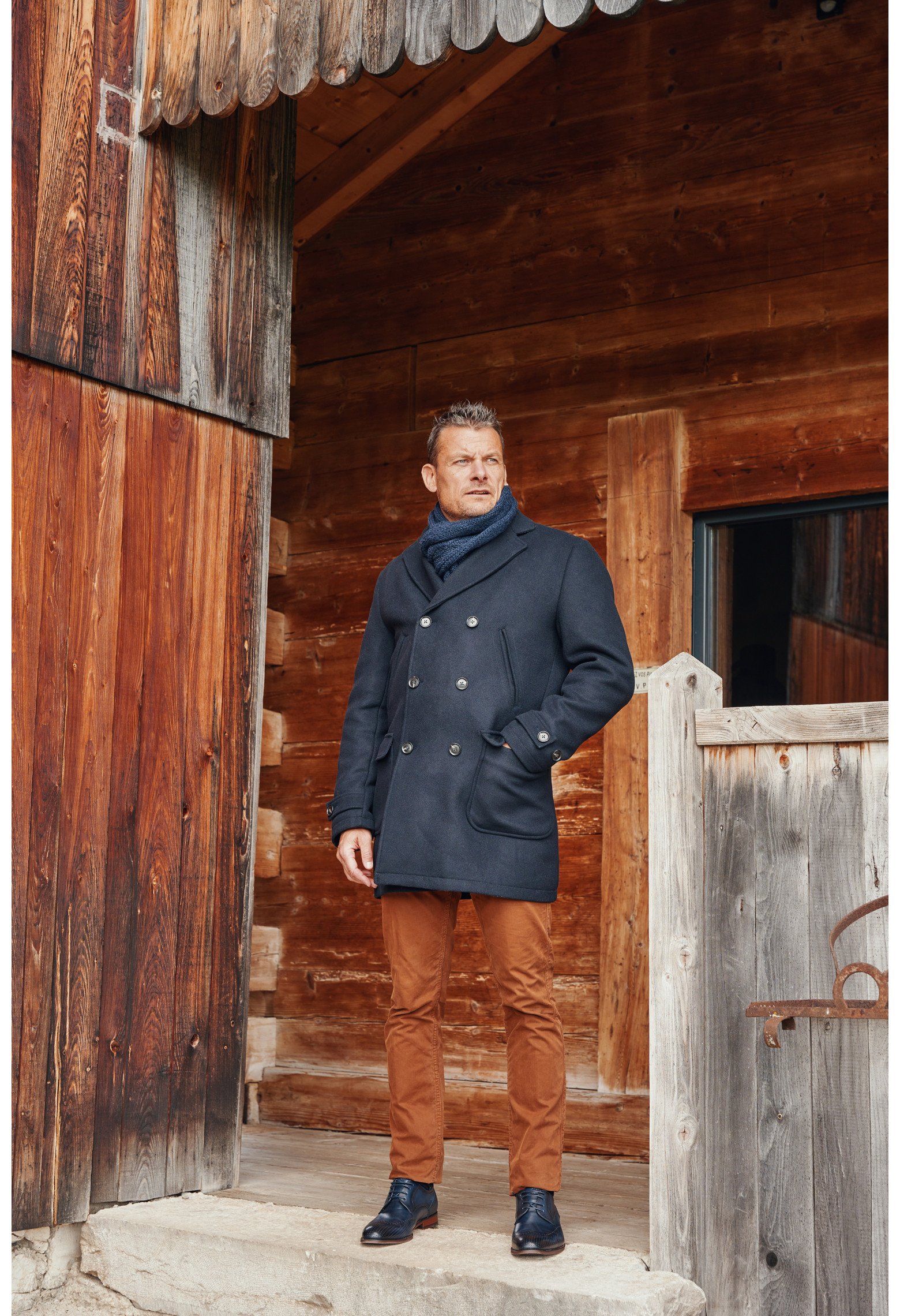 Homme portant le manteau caban LUCERNE marine. Il est long et comporte 2 poches poitrines et 2 poches plaquées.