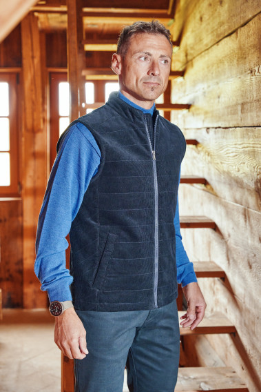 Homme portant la doudoune sans manches PILAT marine. Elle comporte 2 poches repose mains.