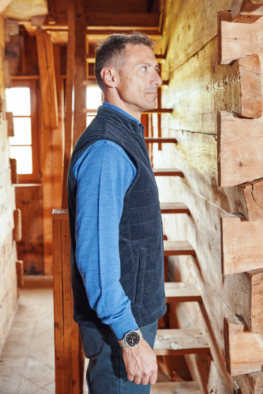 Homme de profil portant la doudoune sans manches PILAT marine.