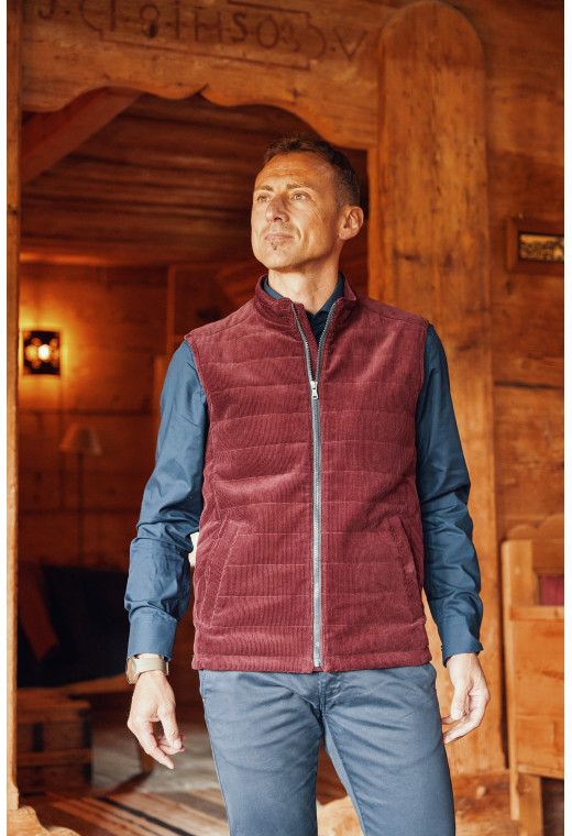 Homme portant la doudoune sans manches PILAT bordeaux. Elle comporte 2 poches repose mains.