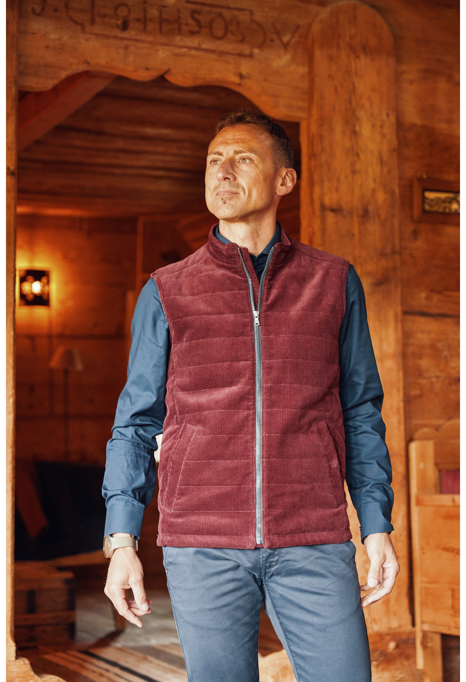 Homme portant la doudoune sans manches PILAT bordeaux. Elle comporte 2 poches repose mains.