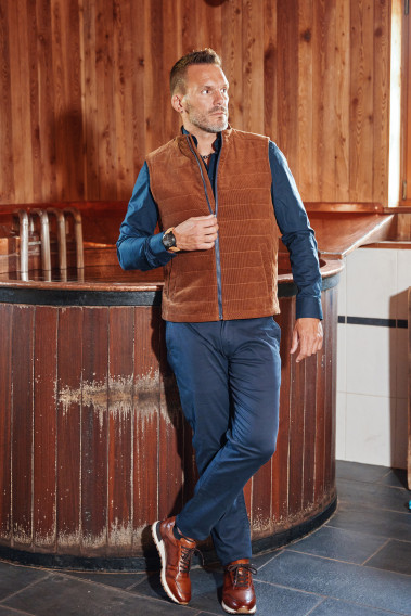 Homme portant la doudoune sans manches PILAT camel. Elle comporte 2 poches repose mains.