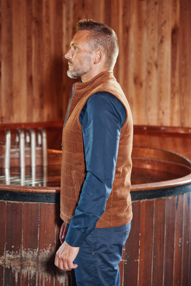 Homme de profil portant la doudoune sans manches PILAT camel.