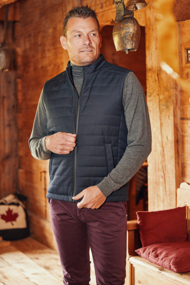 Homme portant la doudoune sans manches PILAT marine. Elle contient 2 poches repose main.