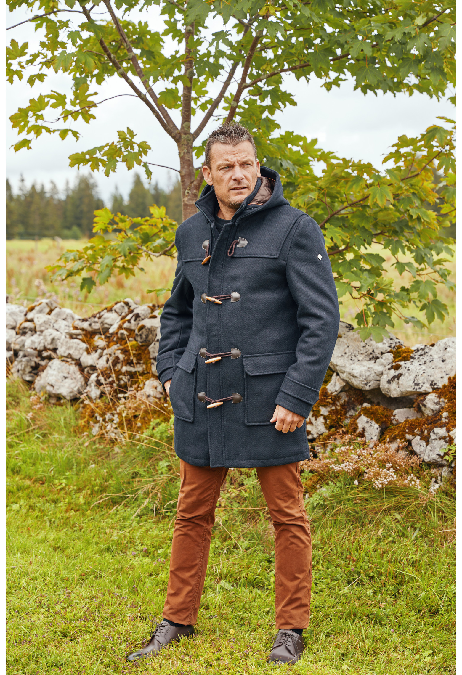 Homme portant le duffle coat YEBO marine. Il est long et  comporte 2 poches plaquées.