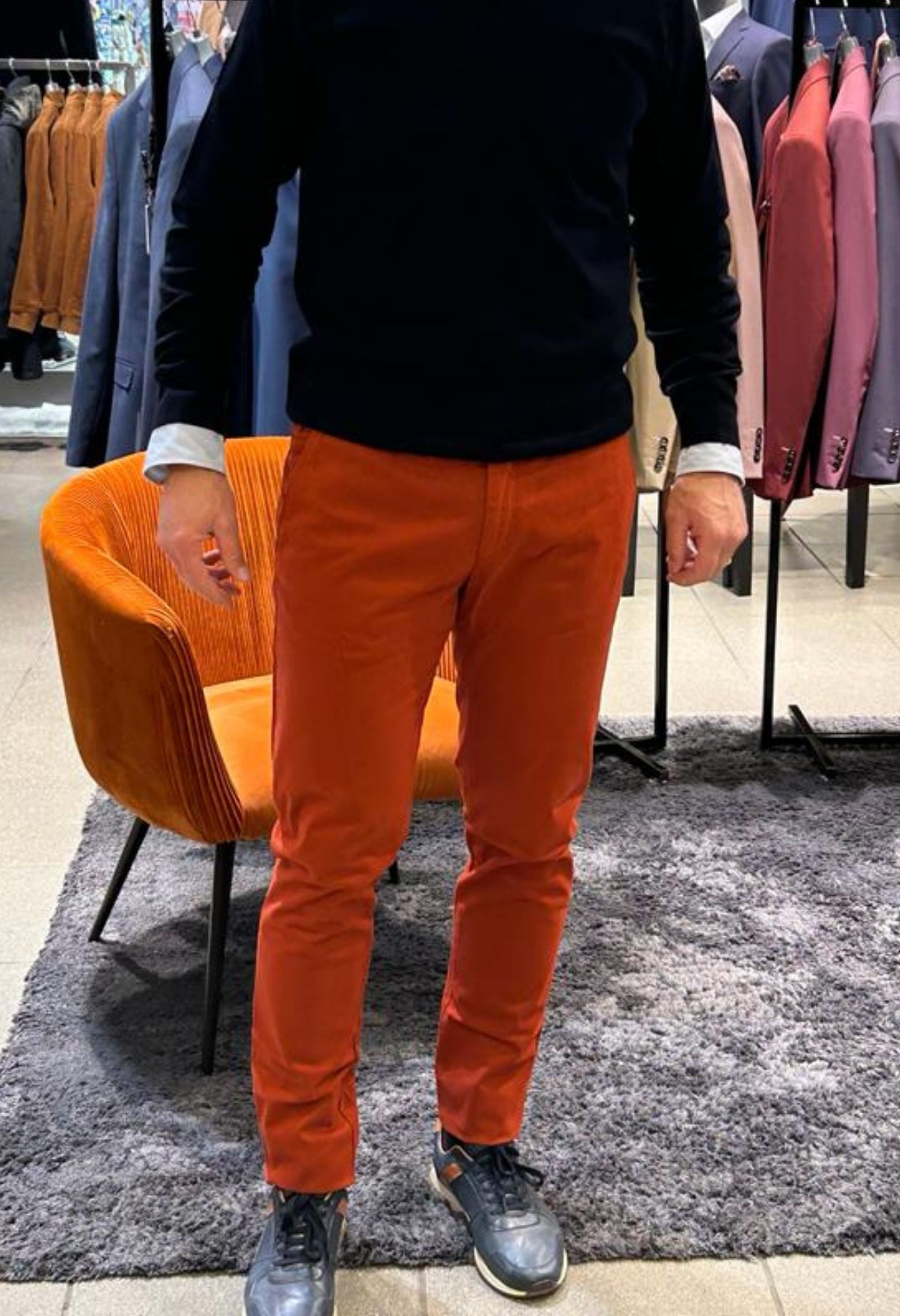 Homme portant le chino PEARL rouille. Il comporte 3 poches avant et 2 poches arrières.