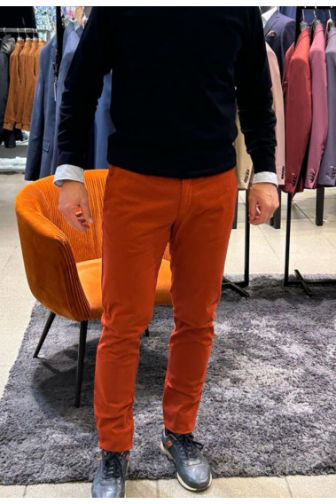 Homme portant le chino PEARL rouille. Il comporte 3 poches avant et 2 poches arrières.