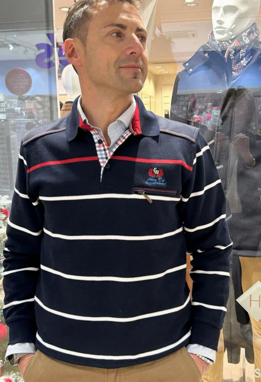Homme portant le polo manches longues marine à rayures. Col chemise et coupe classique.