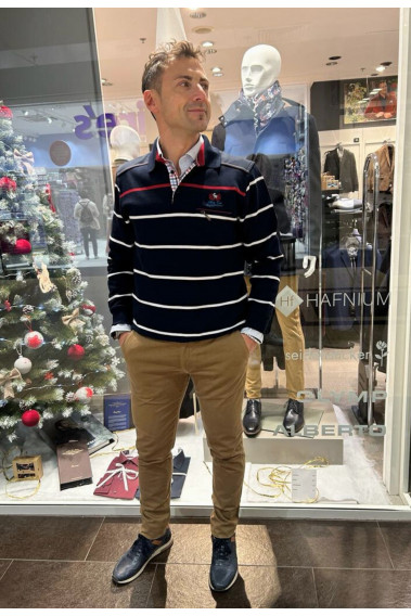 Homme portant le polo manches longues marine à rayures. Col chemise et coupe classique.