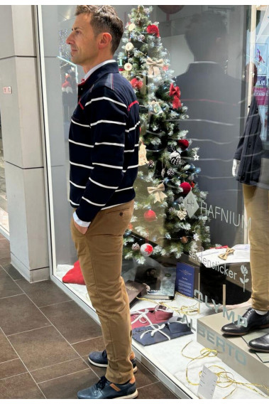 Homme de profil portant le polo manches longues marine à rayures. Col chemise et coupe classique.